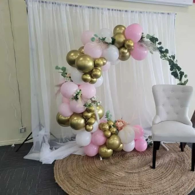 Balloon Arch With Pink, White, and Gold Balloons; a White Chair — Creative Events Innisfail in Tully, QLD