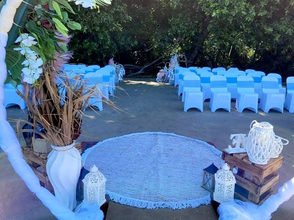 Wedding Ceremony Setup on a Beach With White Chairs, Arch, and Rug — Creative Events Innisfail in Mission Beach, QLD