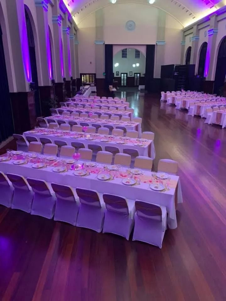 Long Tables Set for a Banquet in a Hall With Purple Uplighting — Creative Events Innisfail in Tully, QLD