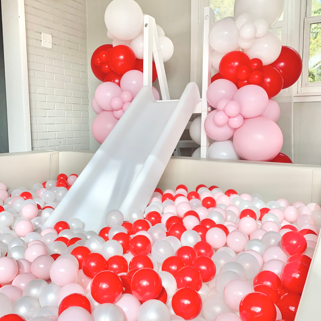 Strawberry-themed pink and red ball pit and slide rental setup for a girl’s birthday party in Philadelphia

