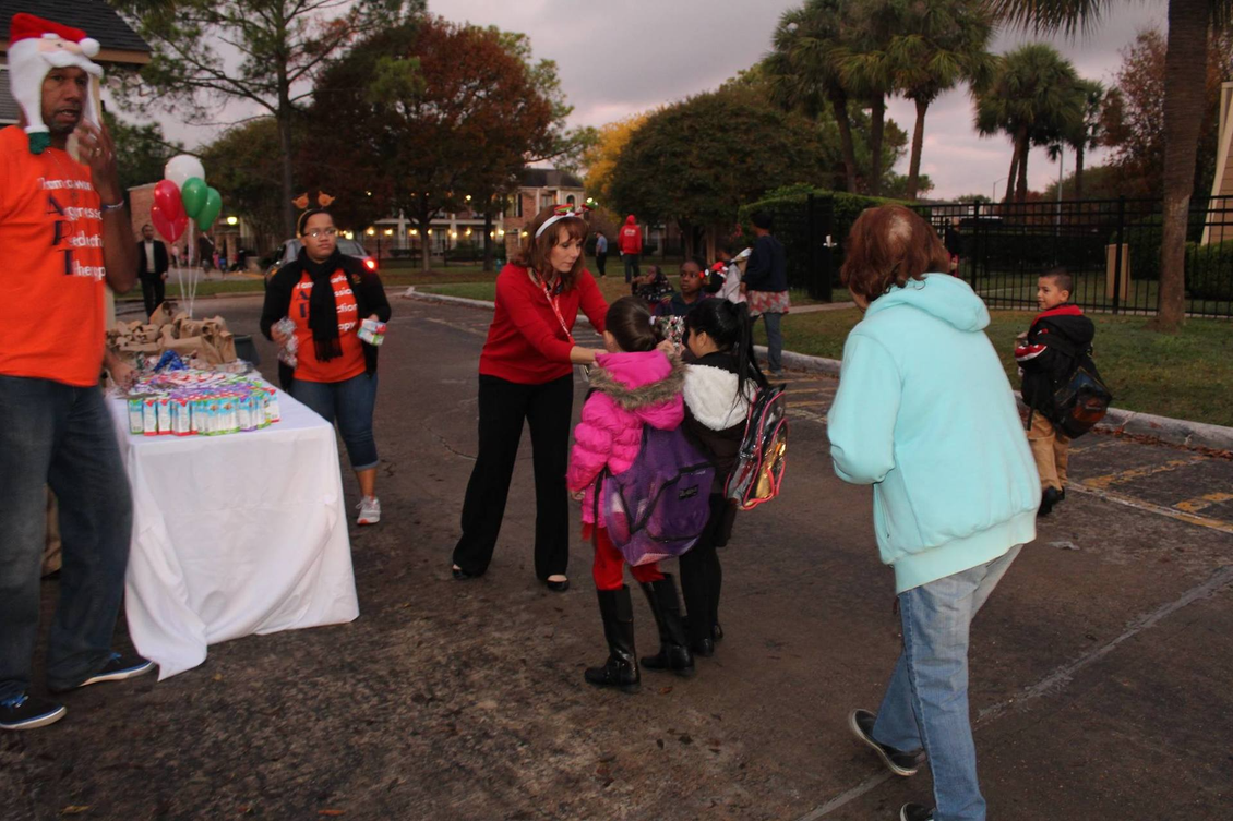 A woman in a santa hat holds a child in her arms