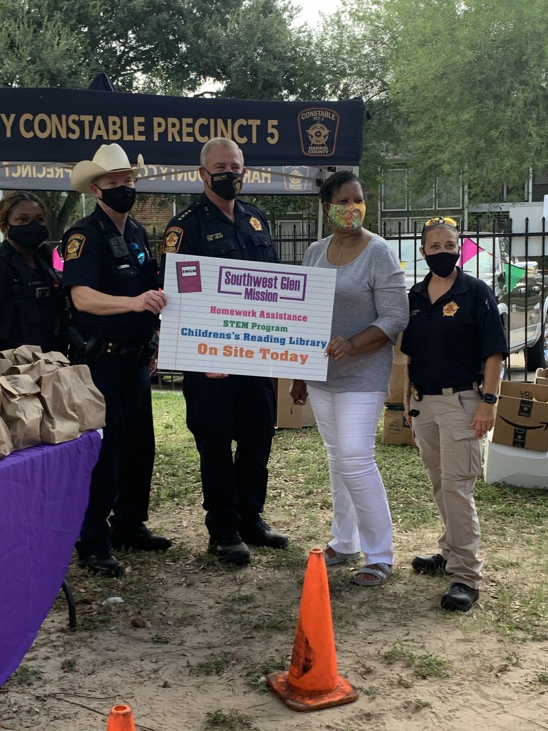 A group of police officers are standing next to a woman holding a sign