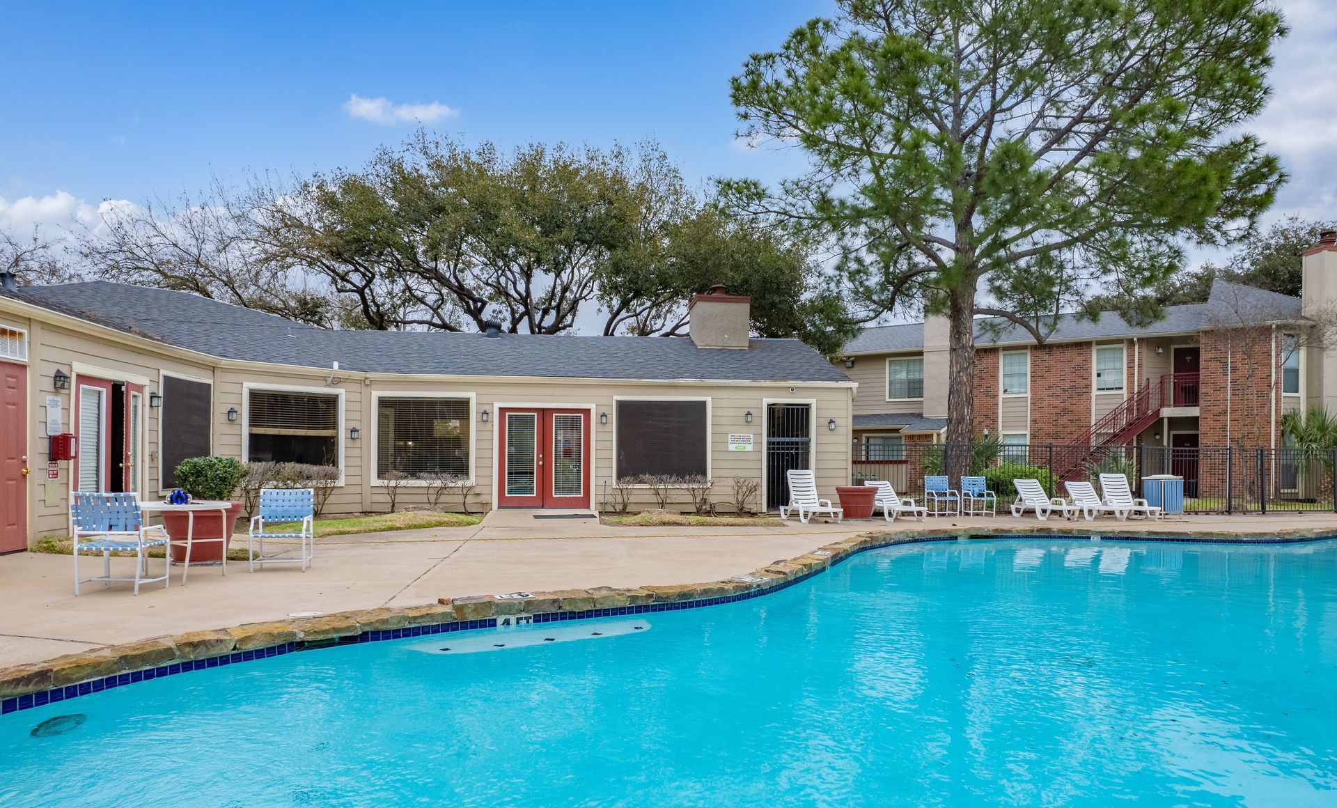 a large apartment building with a pool and a red truck parked in front of it .