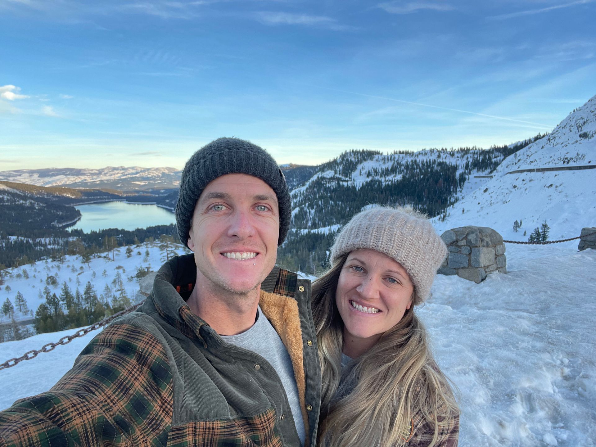 A man and a woman are taking a selfie in the snow.