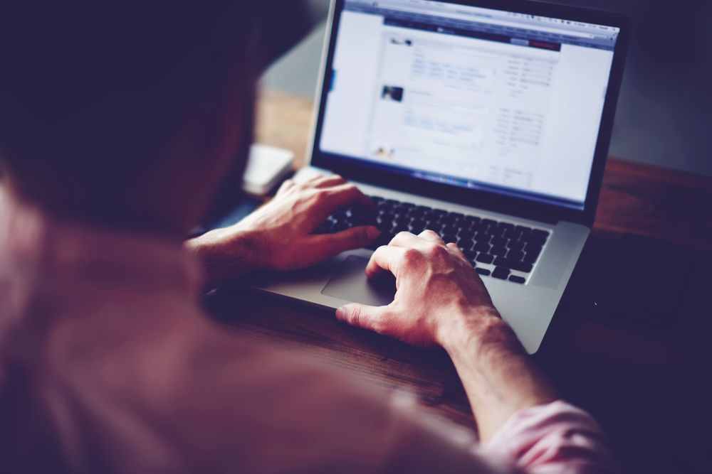 Person Using a Laptop, Typing on The Keyboard, Seen from Behind, Indoors — Wright Partners in Dubbo, NSW