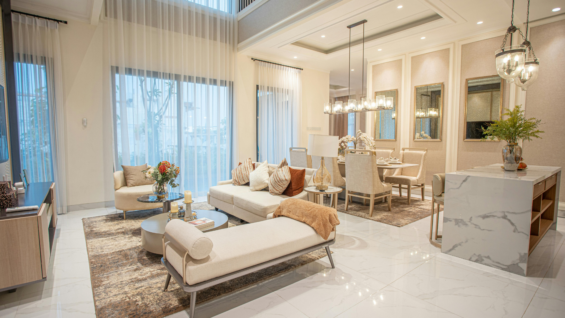 A luxury infinity pool at sunset overlooking a scenic mountain range and coastal landscape from a modern villa balcony.