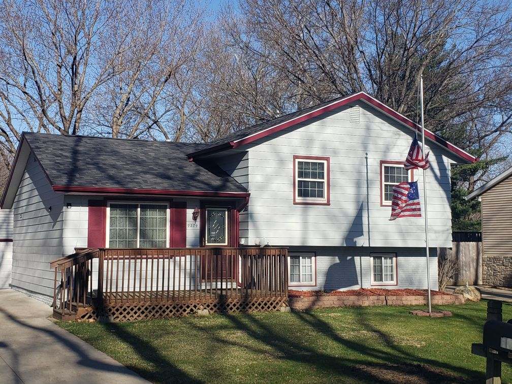 Red Tainted House With Flag — Norwalk, IA — Roofing Experts