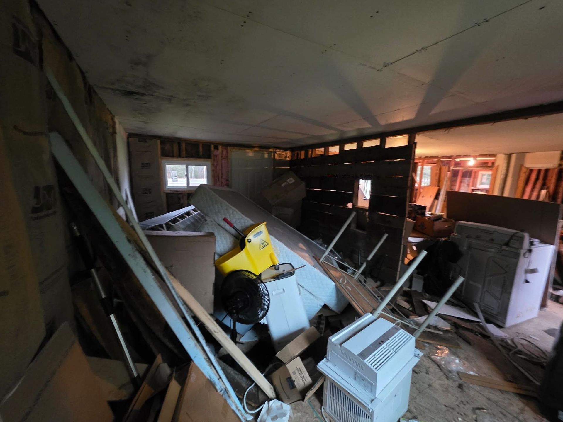Interior of a room with exposed walls and debris. A toy car sits amidst the clutter.