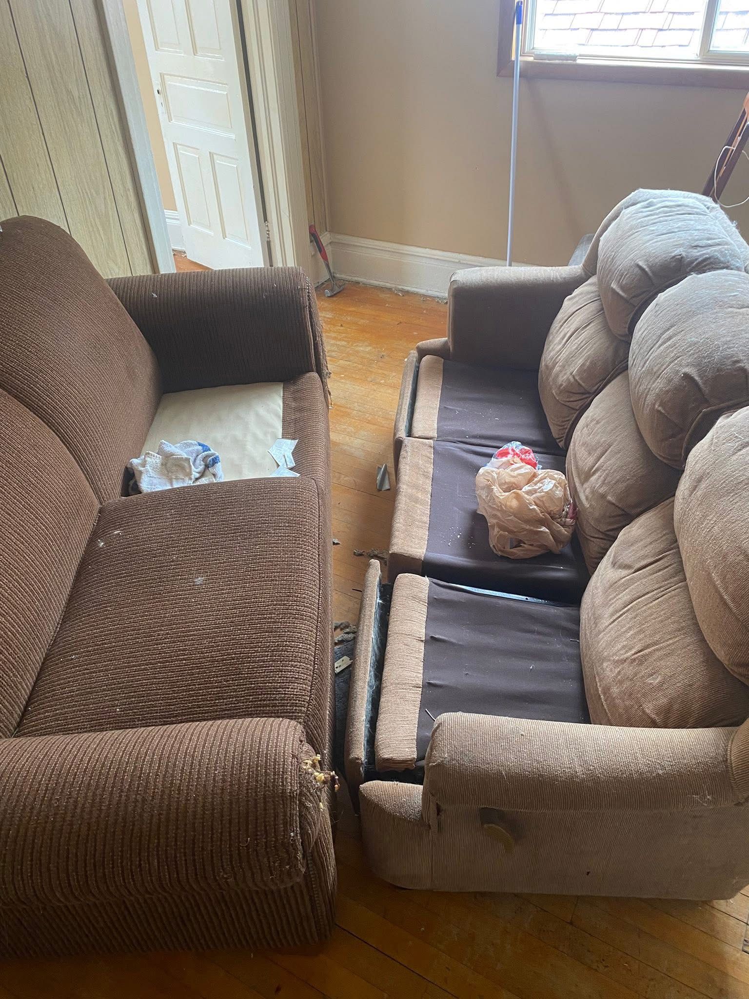 Two brown sofas with patterned cushions in a room with a wooden floor.