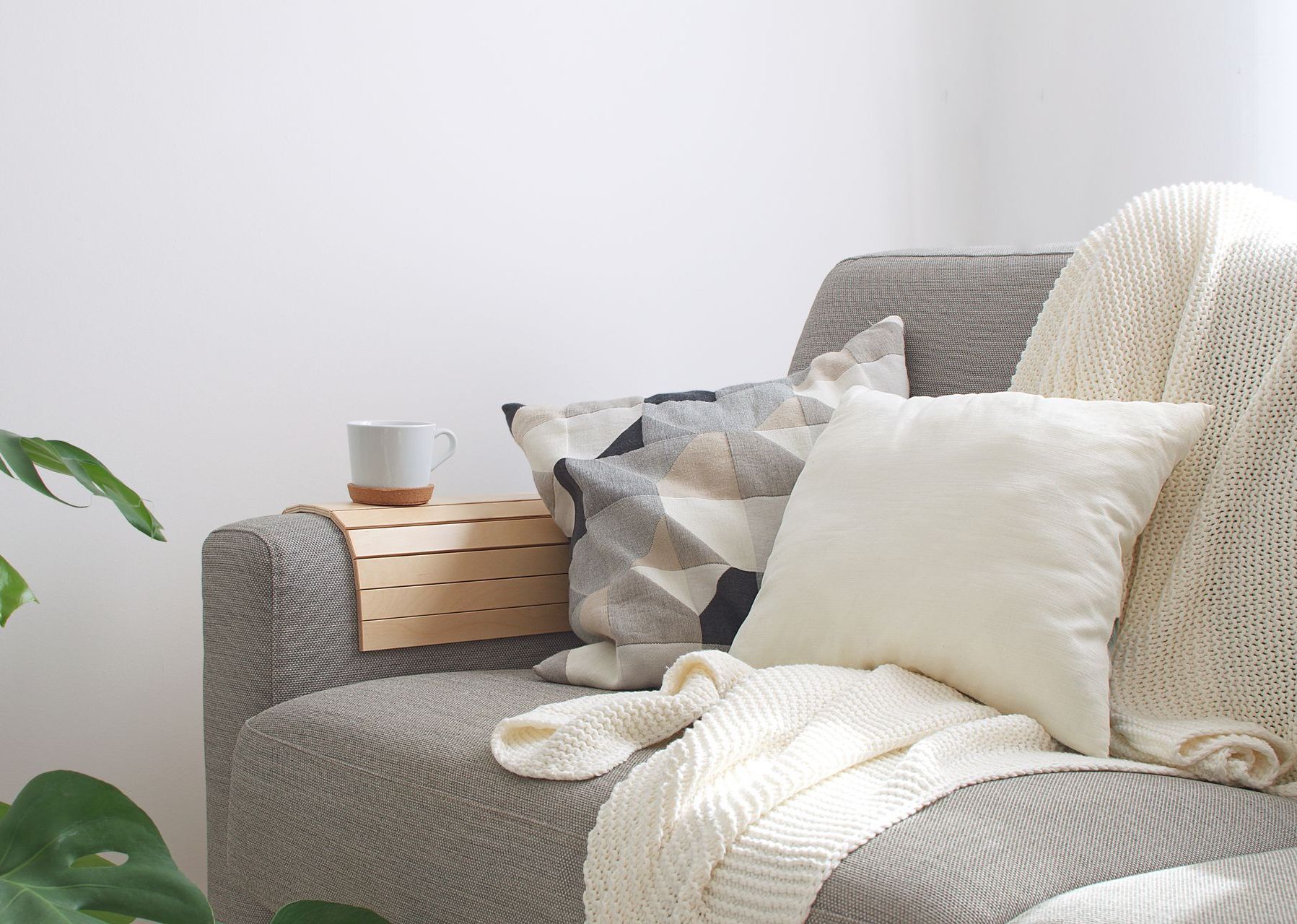 A couch with pillows and a blanket on it in a living room.