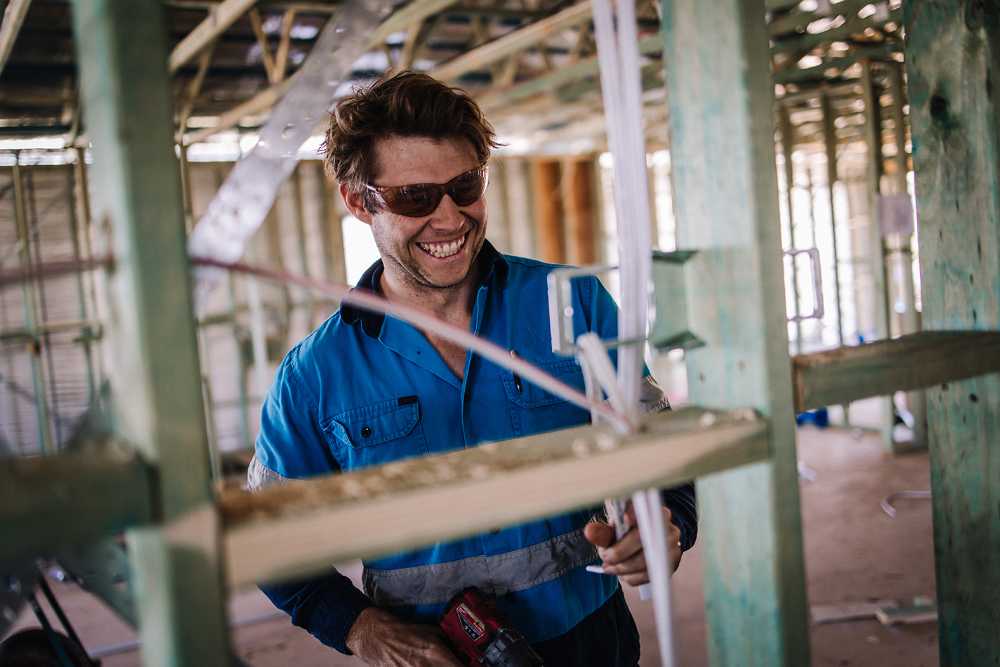 Electrician Smiling and Fixing — Local Electrical Contractors in Tamworth