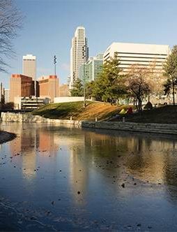 City skyline reflecting in water on a sunny day.