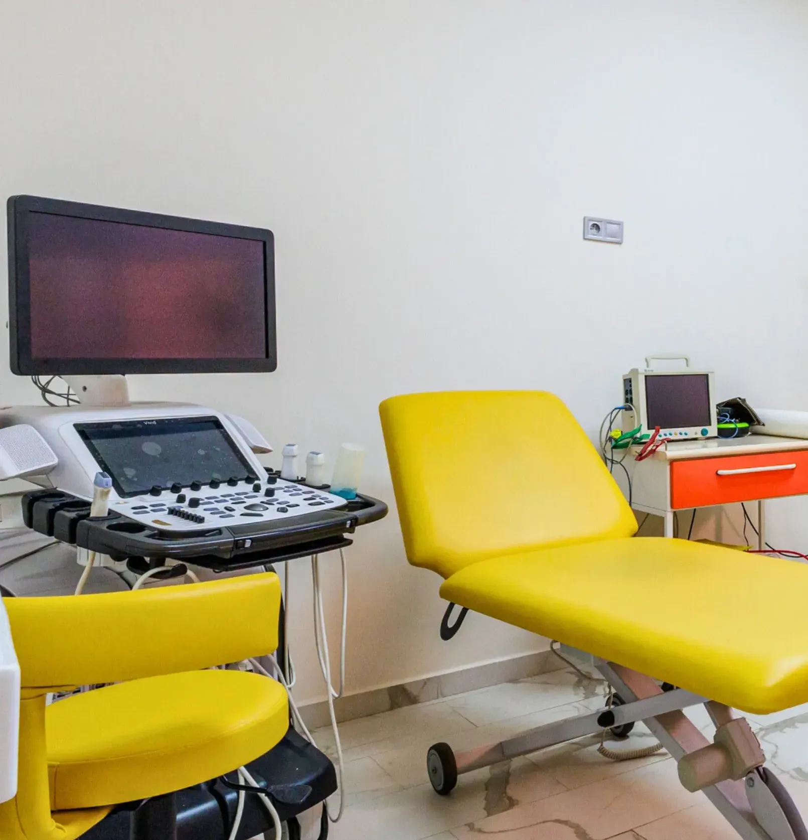 Un cabinet médical avec une chaise jaune et un ordinateur