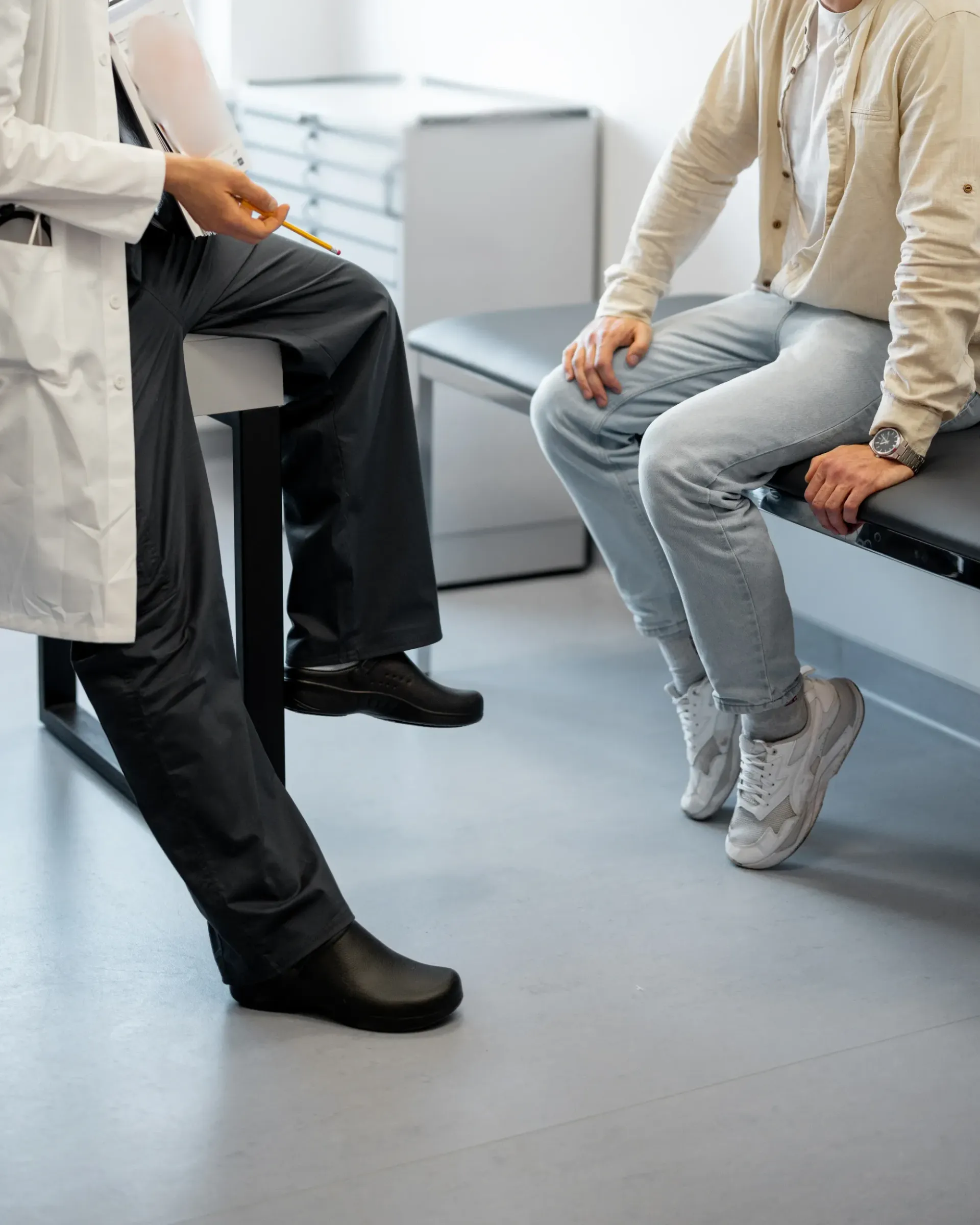 Un médecin parle à un patient assis sur un banc.