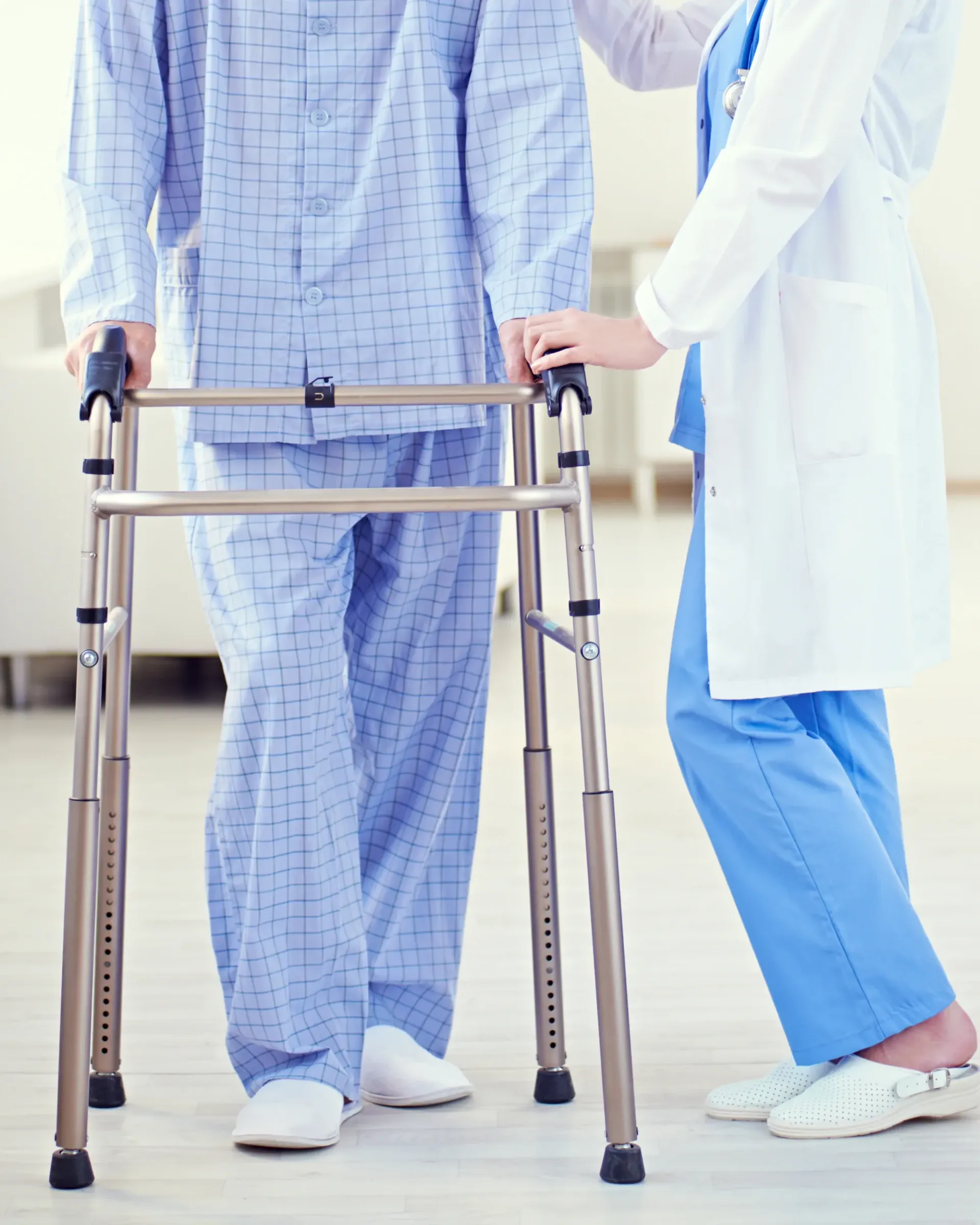 Une infirmière aide un patient à marcher avec un déambulateur