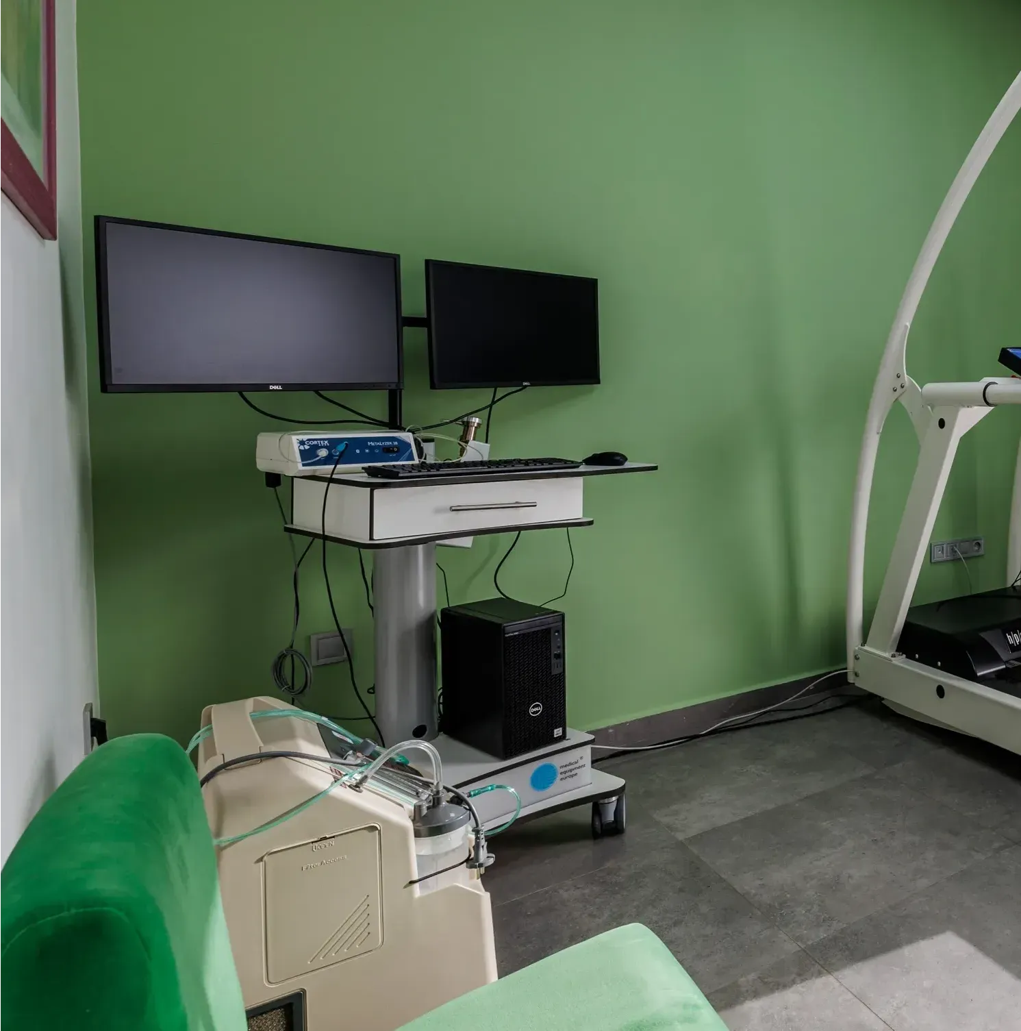 Une pièce avec un tapis roulant et un ordinateur sur un chariot