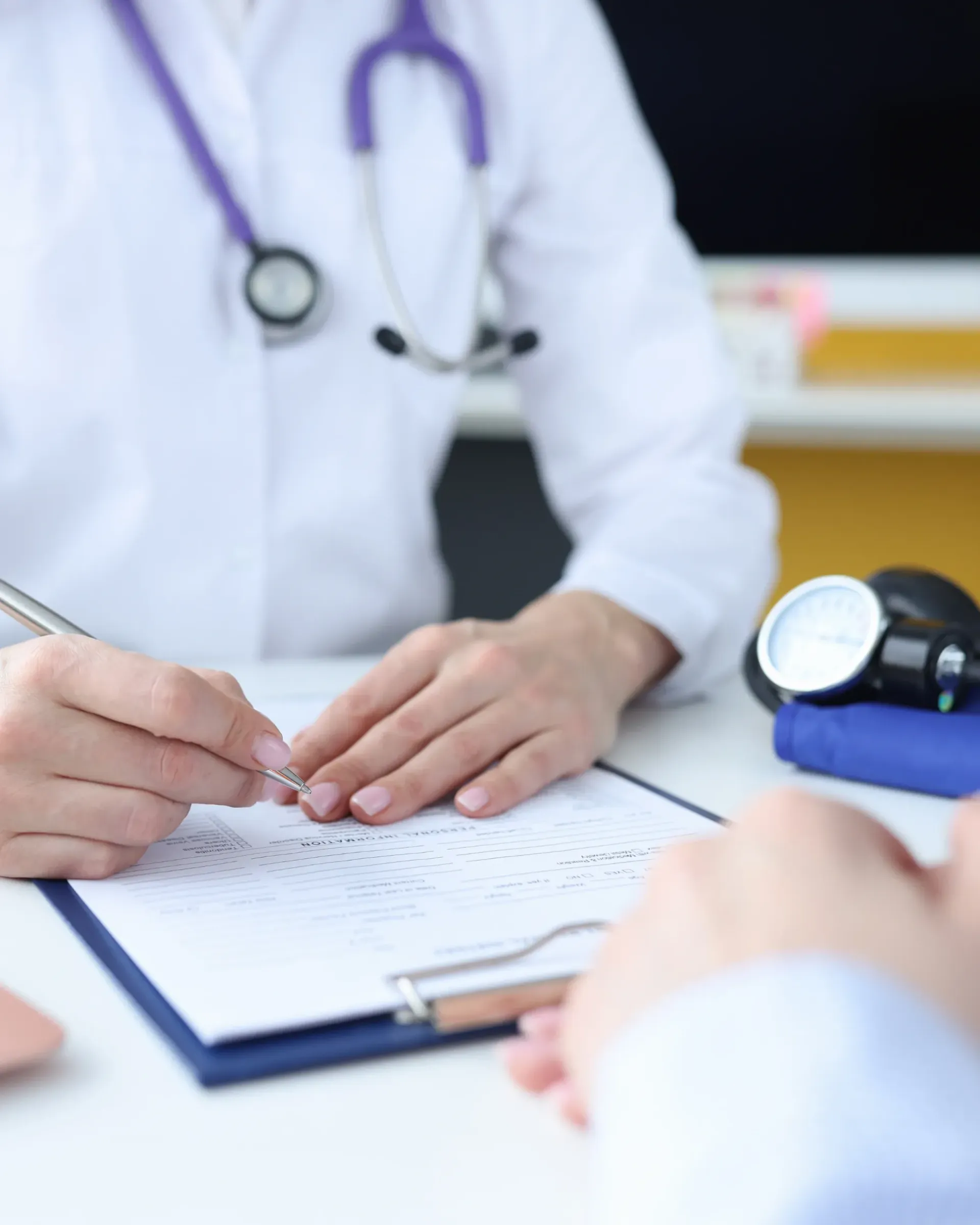 Un médecin écrit sur un presse-papiers avec un stylo