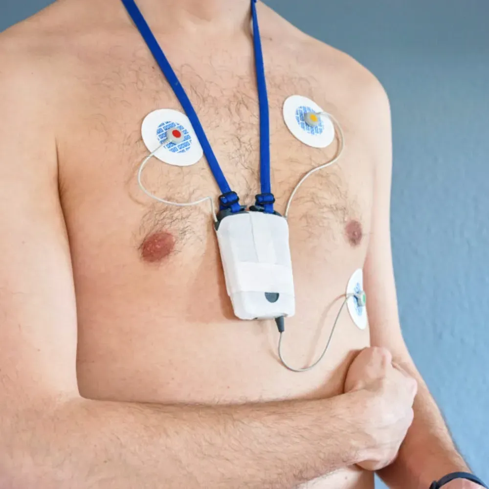 Un homme torse nu a un appareil attaché à sa poitrine