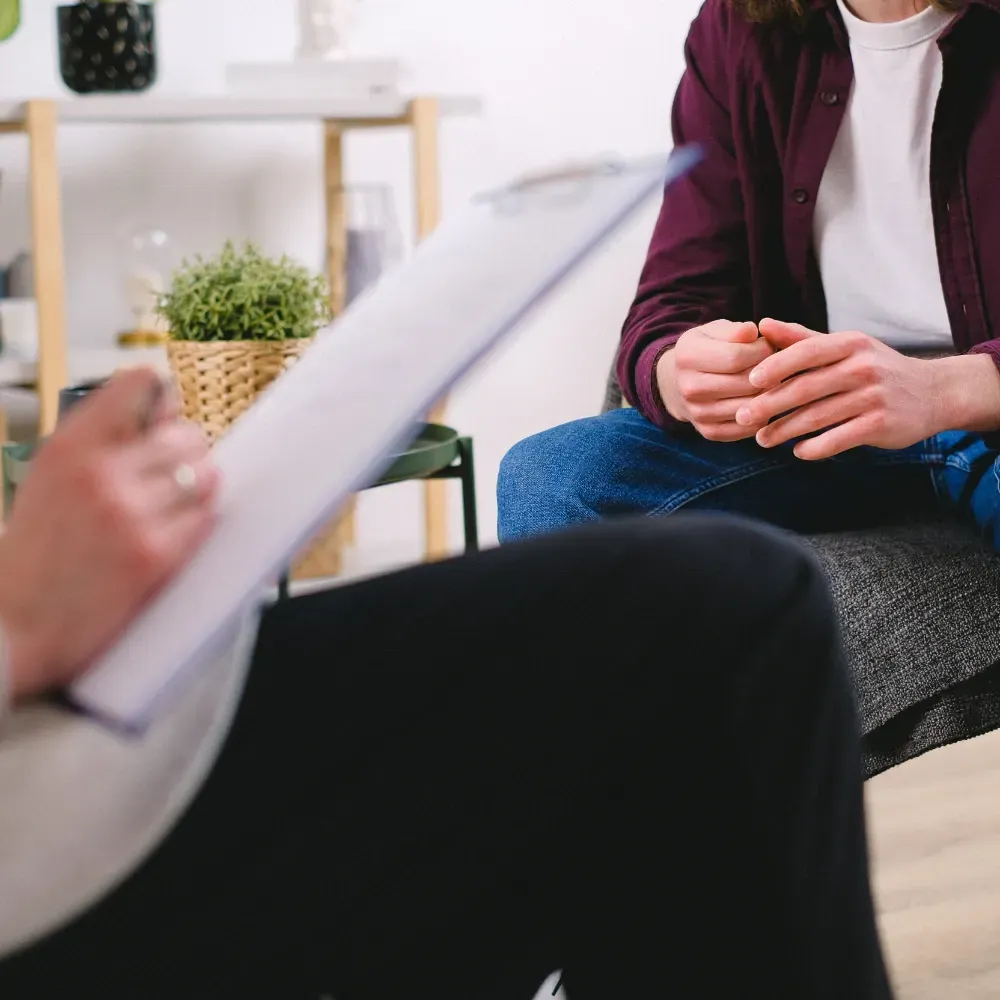 Une femme tient un presse-papiers tout en parlant à un homme.