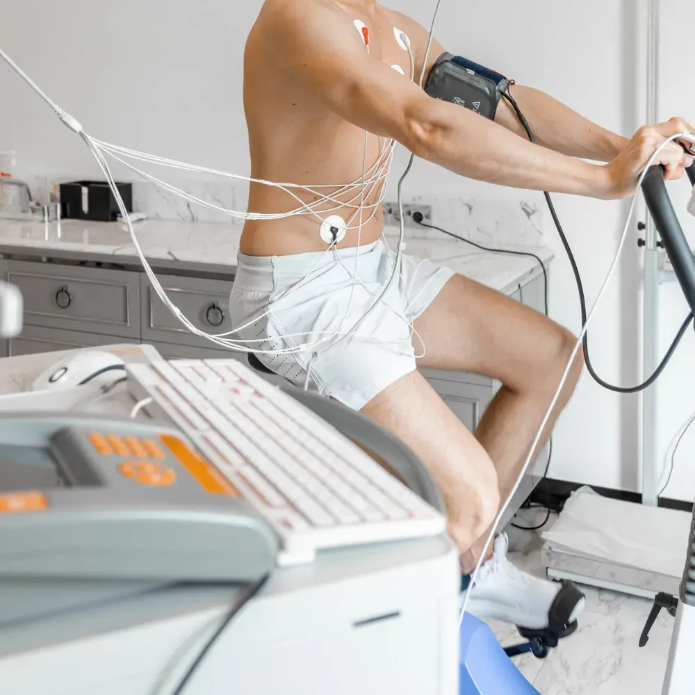 Un homme torse nu est assis sur une machine avec des fils autour de son corps