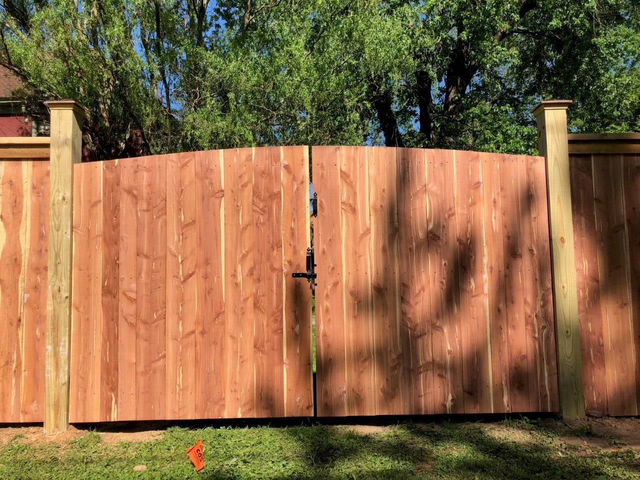 a wooden fence with a gate and trees in the background
