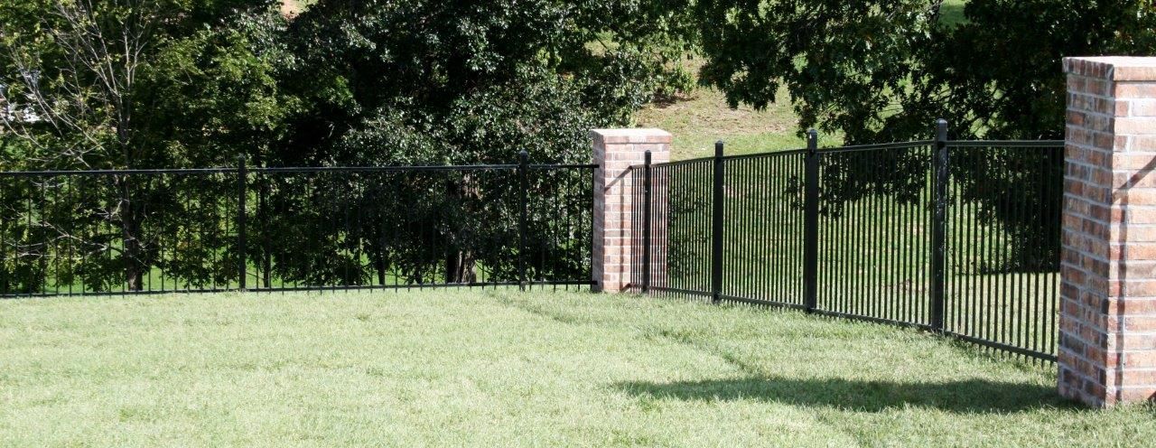long iron fence with brick columns