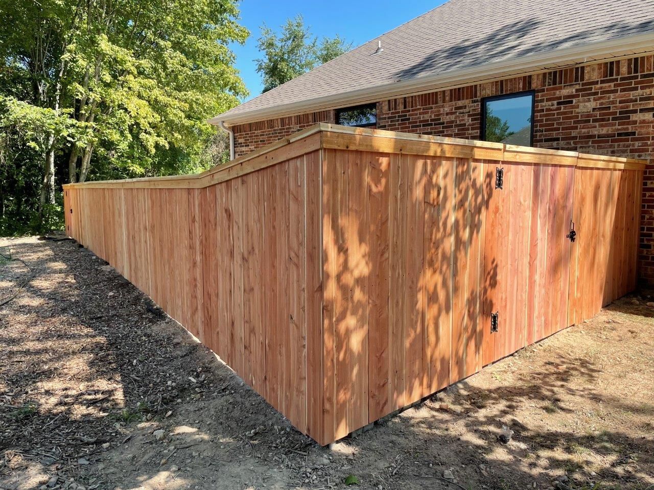 a wooden fence is in front of a brick house