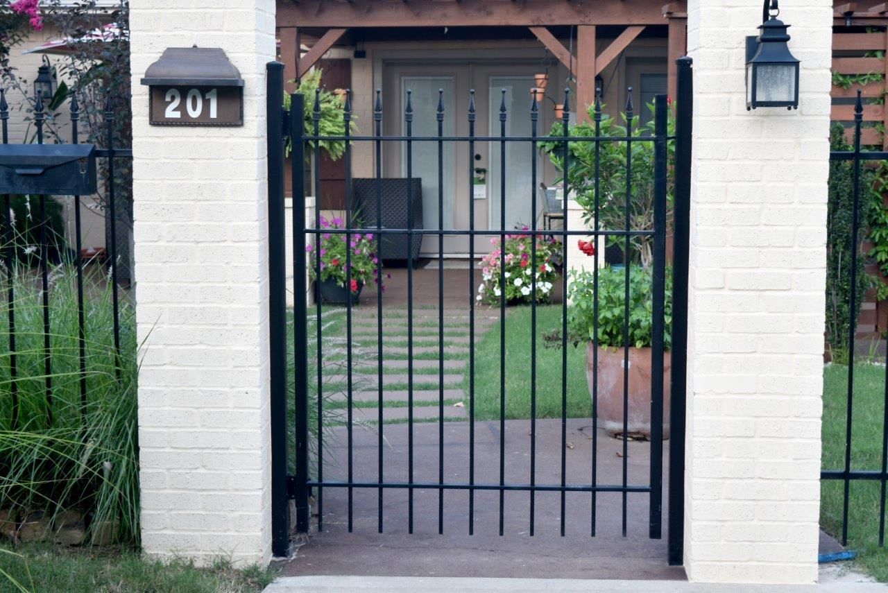 a white brick house with a black gate