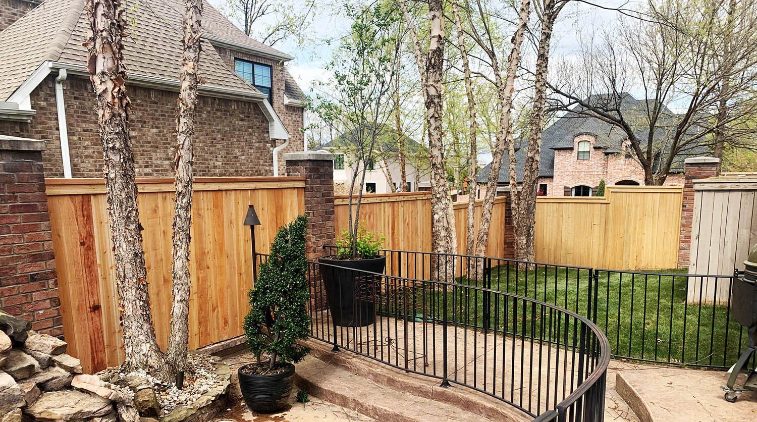 a wooden fence surrounds a brick house