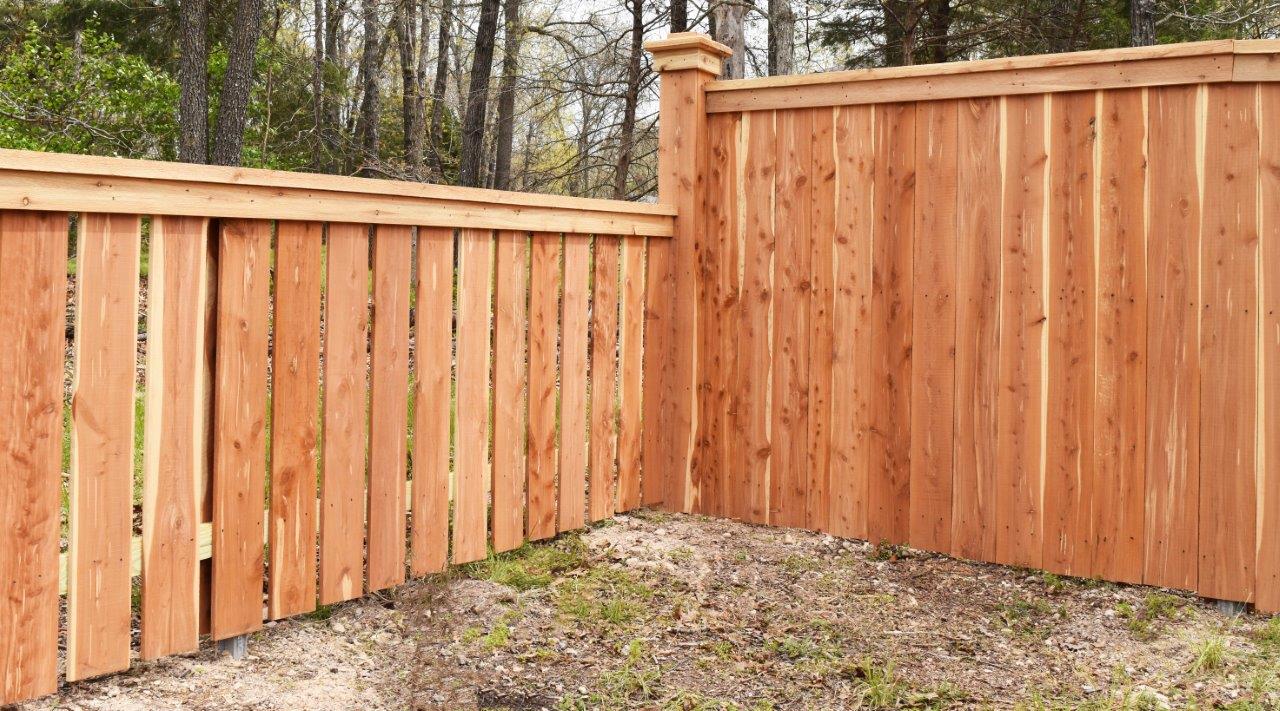 A wooden fence is sitting in the middle of a yard.