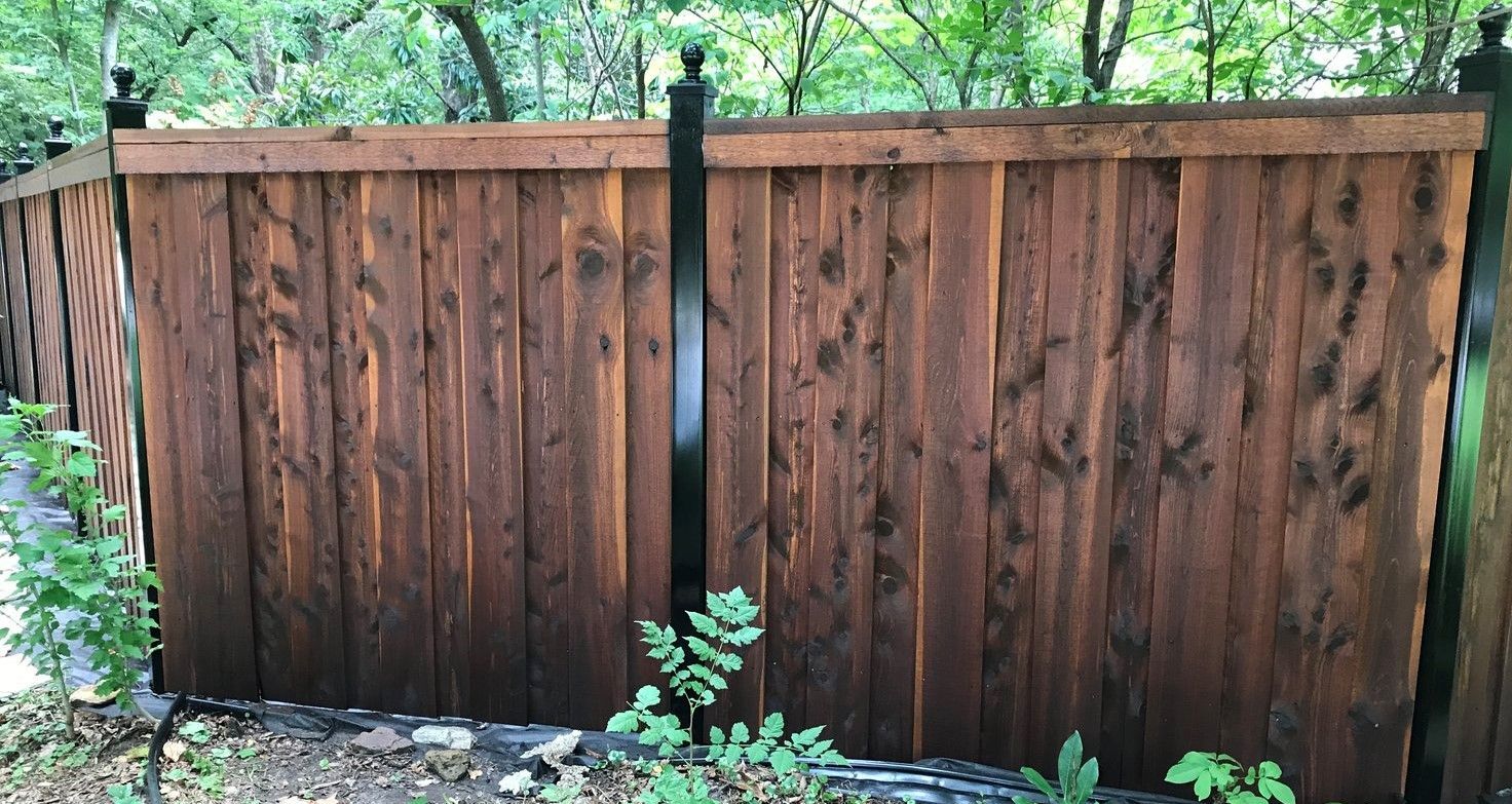 stained wooden fence with metal posts
