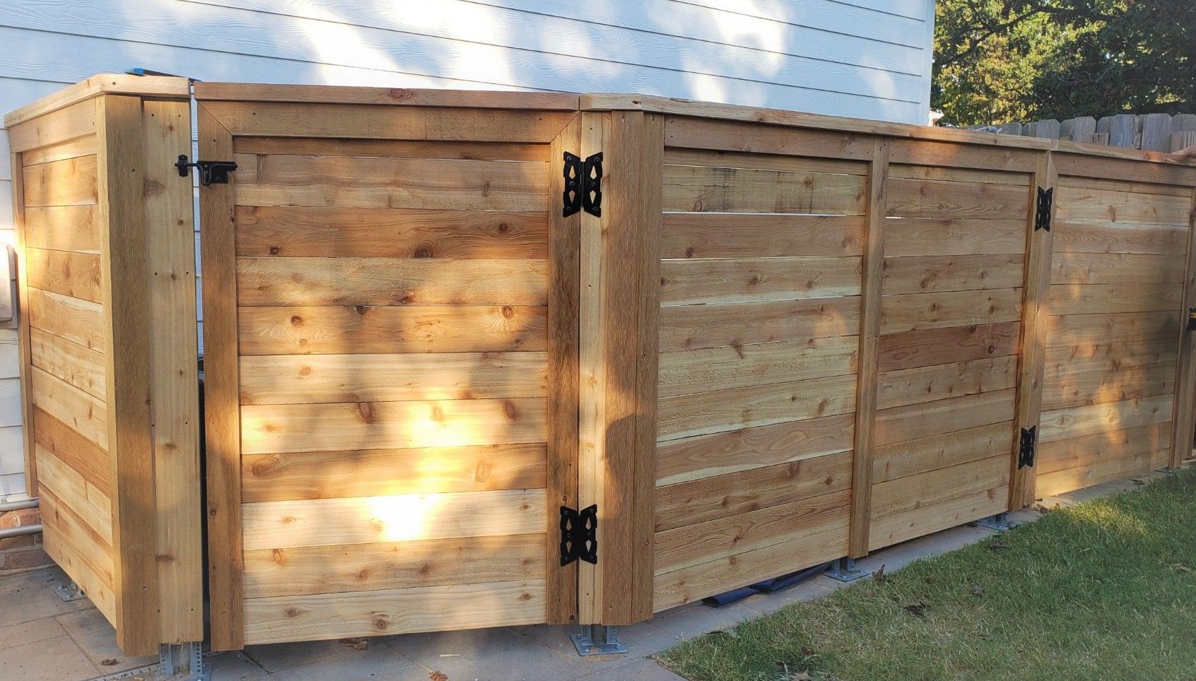 A wooden fence with a gate in front of a house.