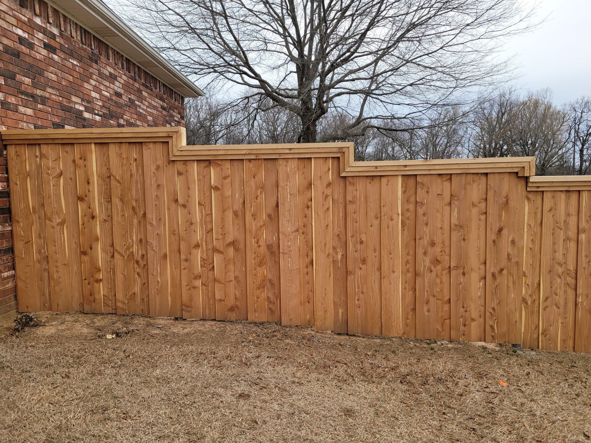 Stepped cedar fence with cap and trim
