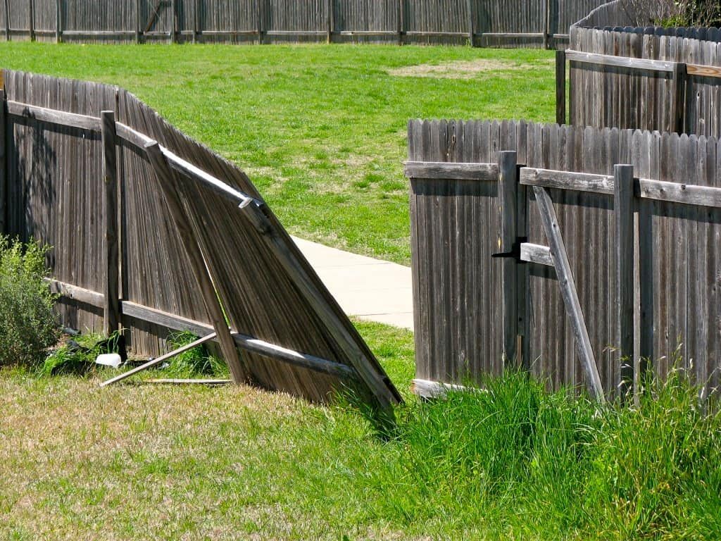a broken wooden fence is sitting in the grass