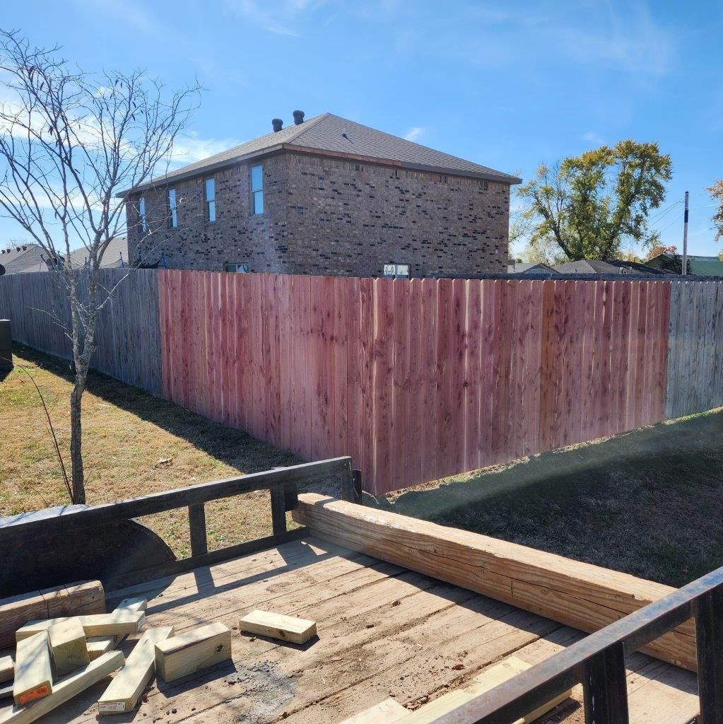 a wooden fence is being built in front of a brick house