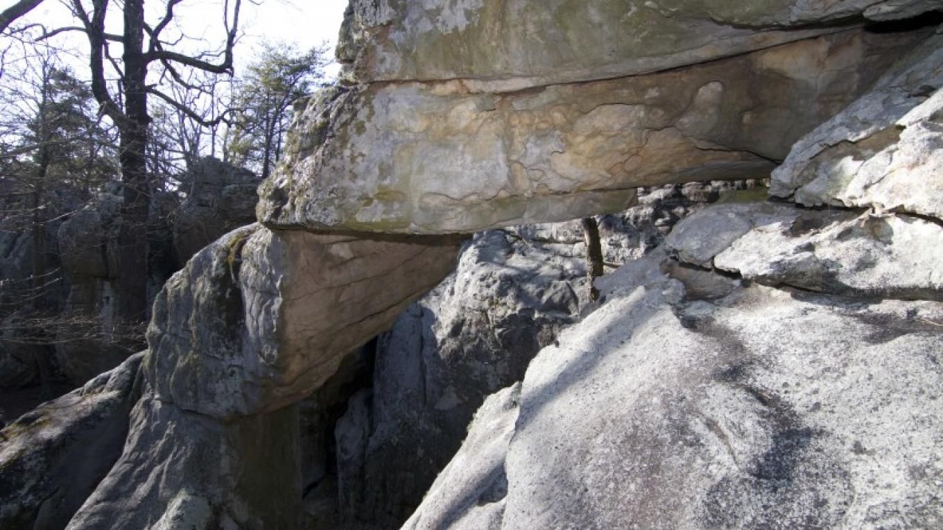 Overhanging rock formation, natural archway, sunlit.