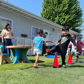 A group of children are playing outside in front of a house.