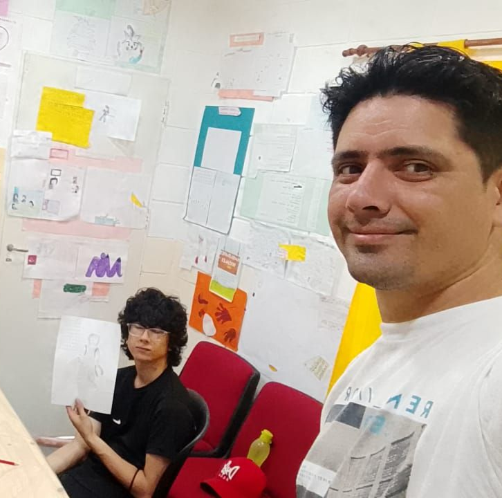 Niños y adultos en una actividad artesanal, creando arte y jugando juntos, en un entorno interior.