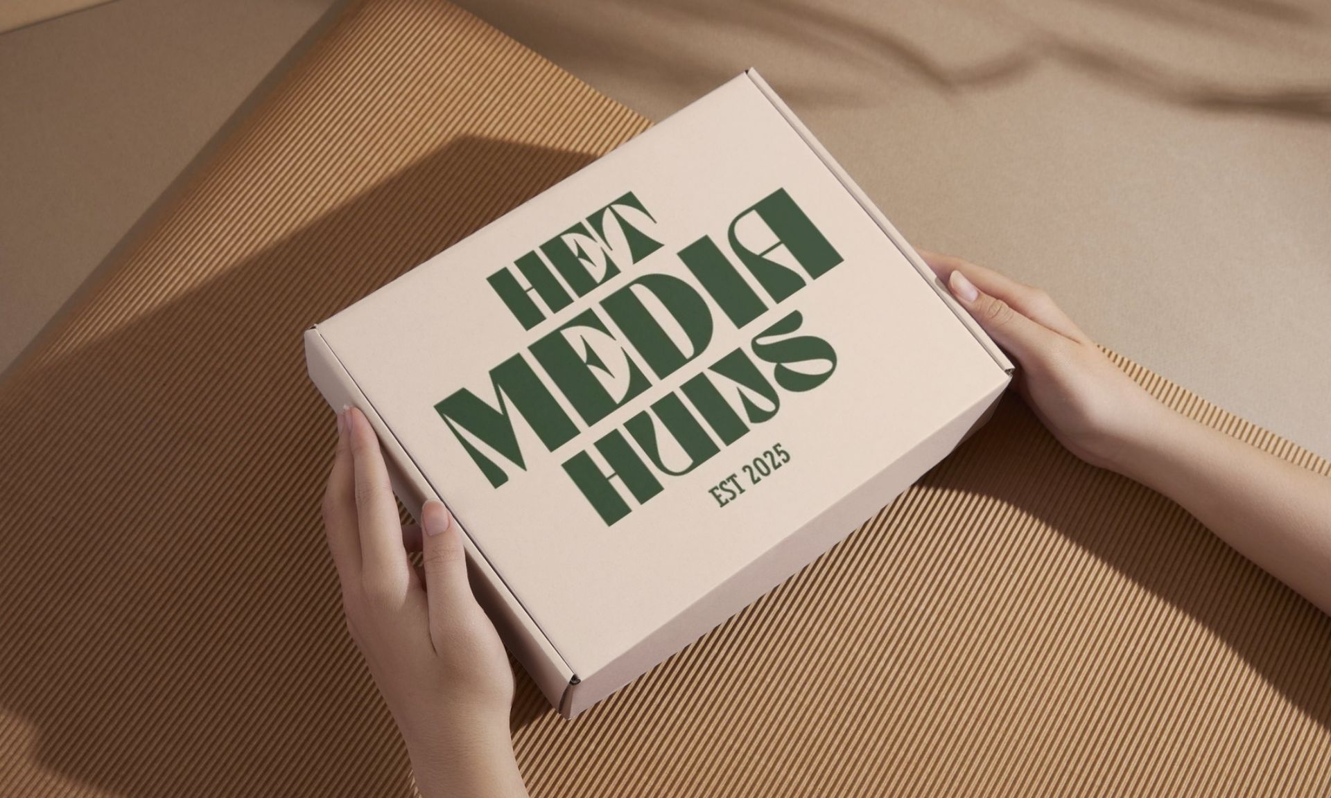 Een persoon houdt een doos vast met de tekst 'het media huijs'
