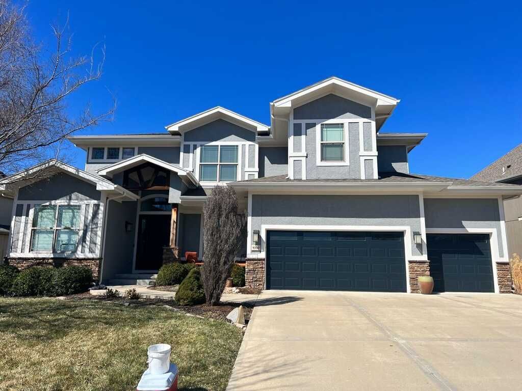 A Large House With Two Garage Doors And A Blue Sky In The Background – Olathe, KS - JJR Painting