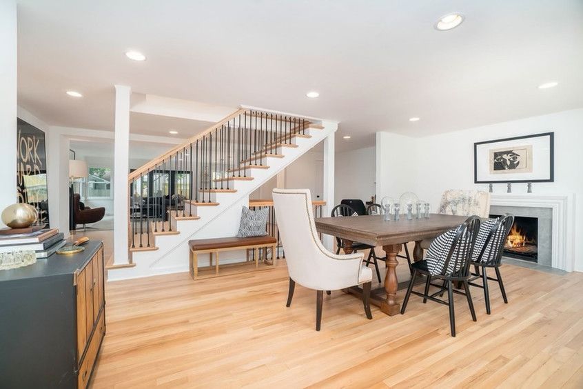 A Dining Room With A Table And Chairs And Stairs Leading Up To The Second Floor – Olathe, KS - JJR Painting