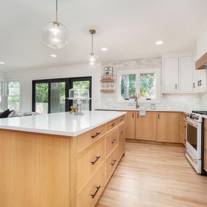 A Kitchen With Wooden Cabinets And White Counter Tops – Olathe, KS - JJR Painting