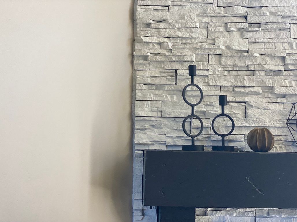 A Fireplace With Two Candle Holders On It And A Stone Wall Behind It – Olathe, KS - JJR Painting