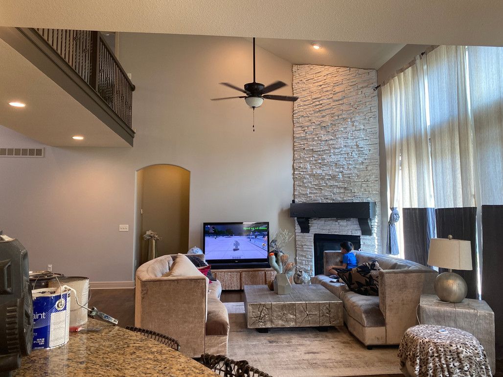 A Living Room With A Fireplace And A Flat Screen Television – Olathe, KS - JJR Painting