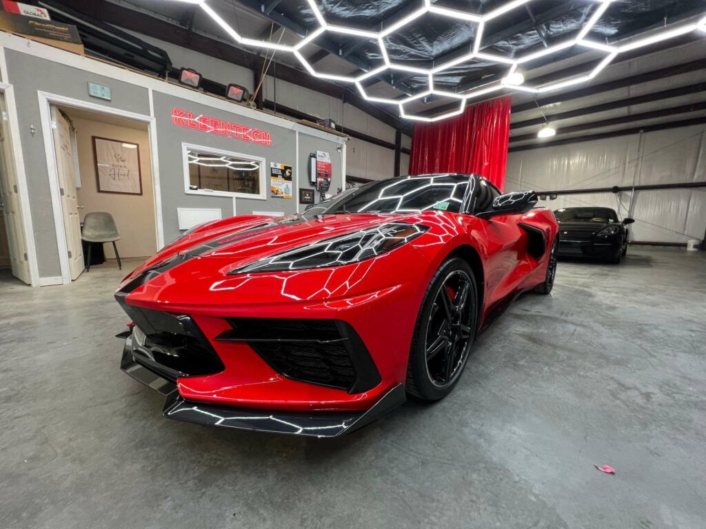A red sports car is parked in a garage.