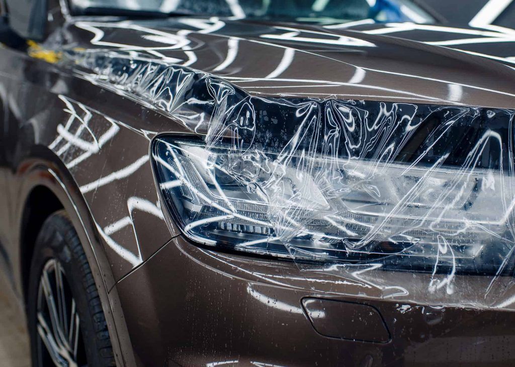 A close up of a car with a protective film on it.