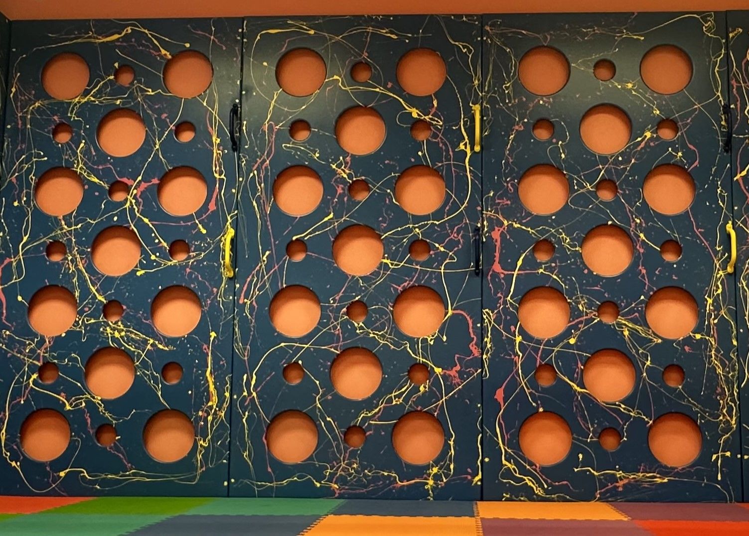 Decorative blue sensory room wall panel with colorful abstract paint splatter design
