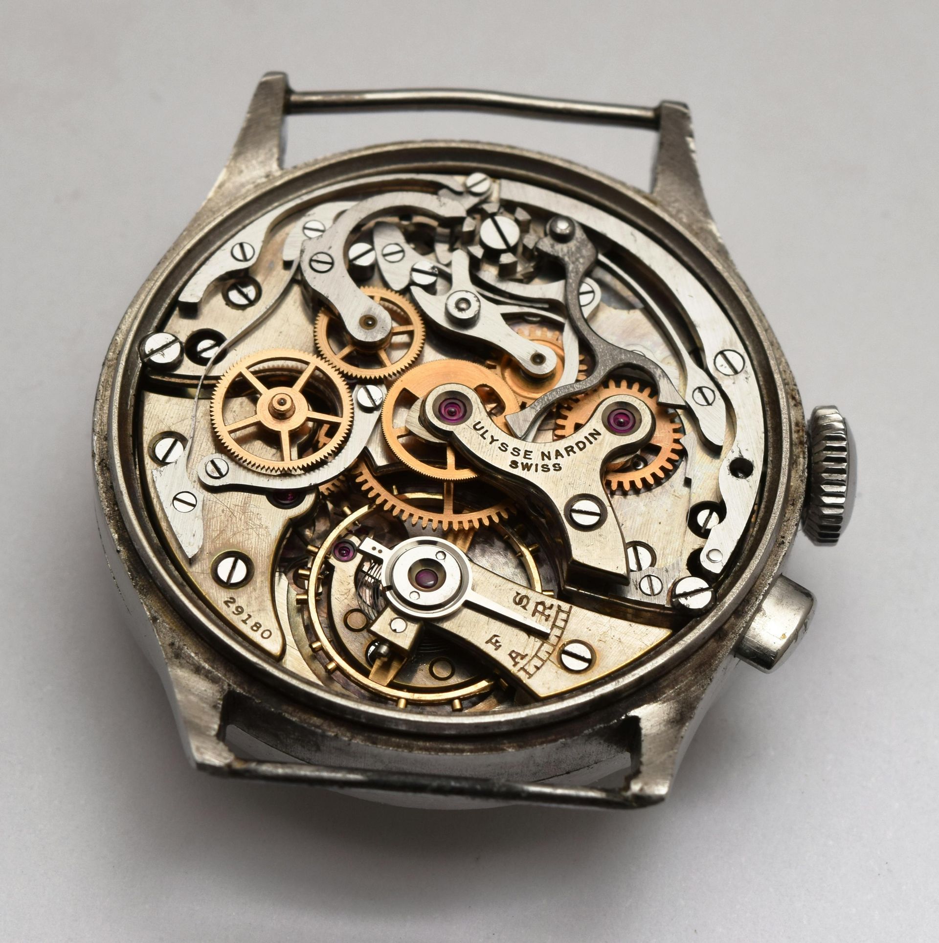 Close-up of a wristwatch's mechanical movement, showing intricate gears, jewels, and other components.