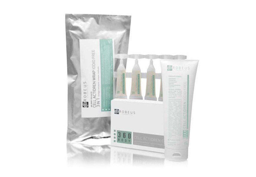 Una bottiglia di lozione e una bustina di lozione sono appoggiate una accanto all'altra su una superficie bianca.