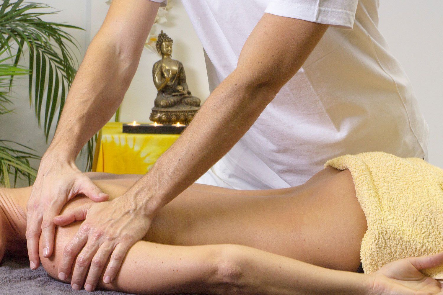 Una donna è sdraiata su un lettino e riceve un massaggio da un uomo.